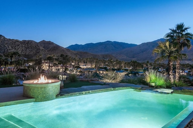 view of pool with a mountain view and an outdoor fire pit