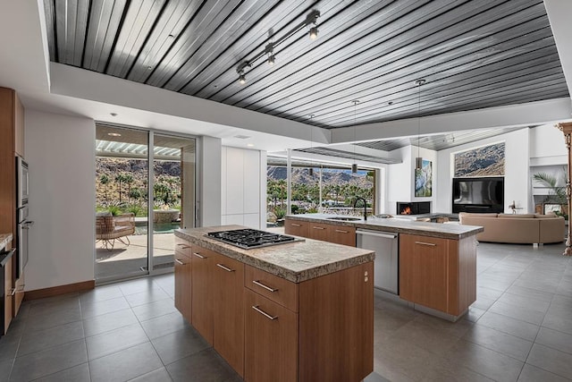 kitchen with a kitchen island, a wealth of natural light, and appliances with stainless steel finishes