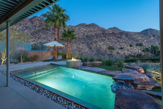 view of swimming pool featuring a mountain view and a fire pit