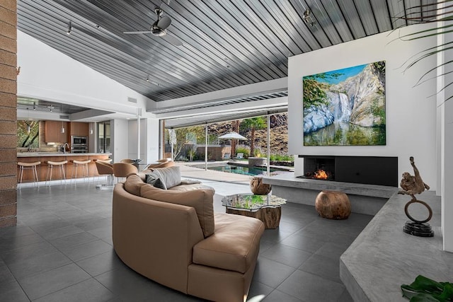 living room with sink, ceiling fan, and lofted ceiling