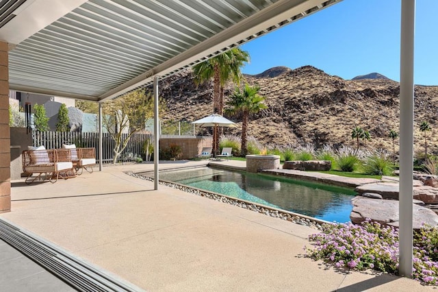 view of patio / terrace featuring a fenced in pool and a mountain view