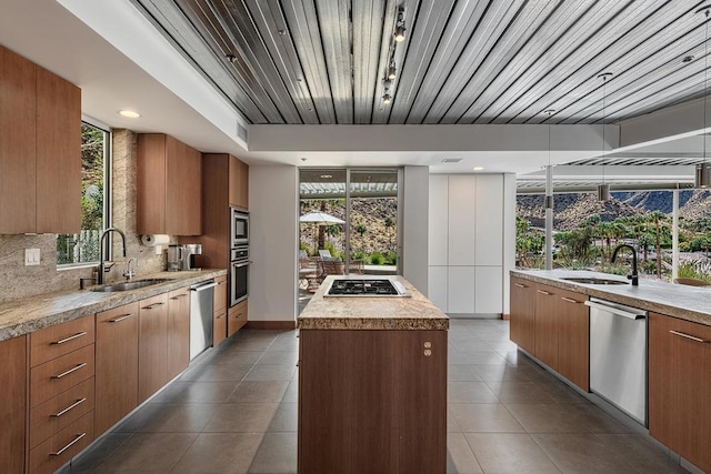 kitchen with sink, backsplash, a center island, and appliances with stainless steel finishes