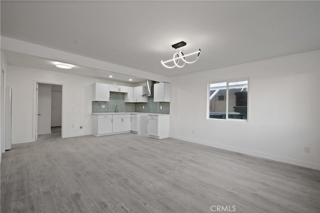 unfurnished living room featuring light hardwood / wood-style floors and an inviting chandelier