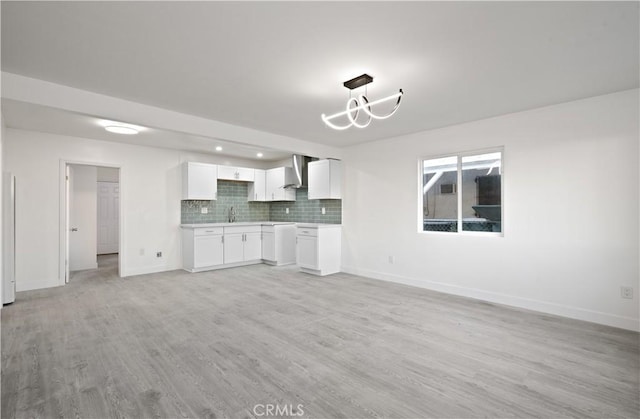 unfurnished living room with sink, light hardwood / wood-style flooring, and a chandelier