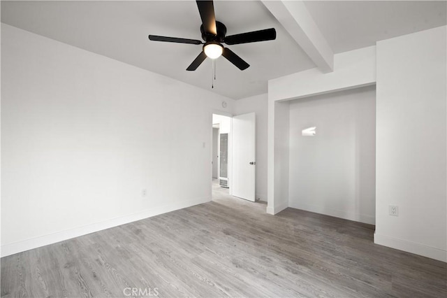 spare room with ceiling fan, beam ceiling, and hardwood / wood-style floors