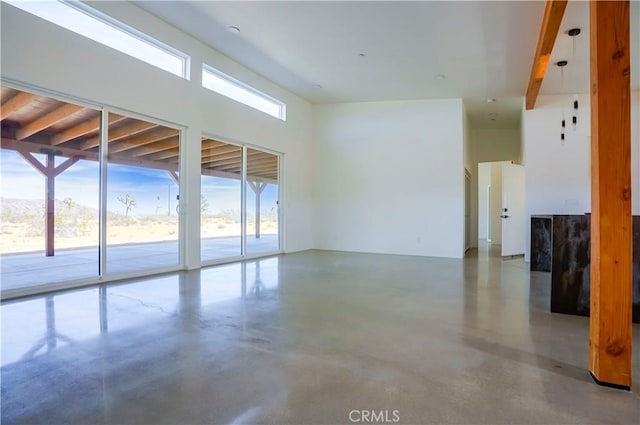 unfurnished room with beamed ceiling