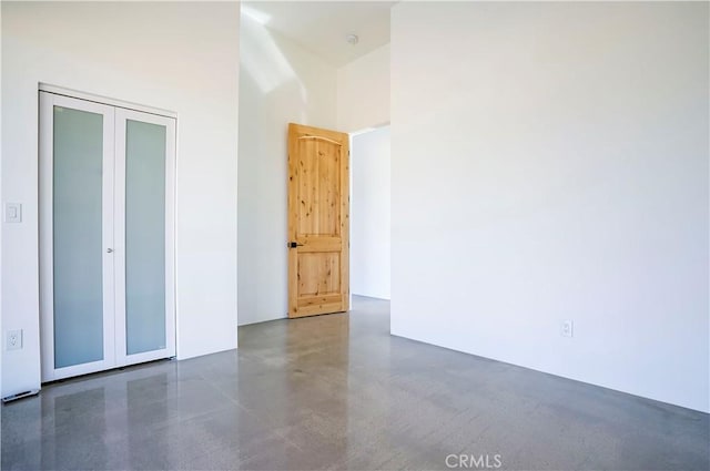 unfurnished bedroom featuring a high ceiling and a closet