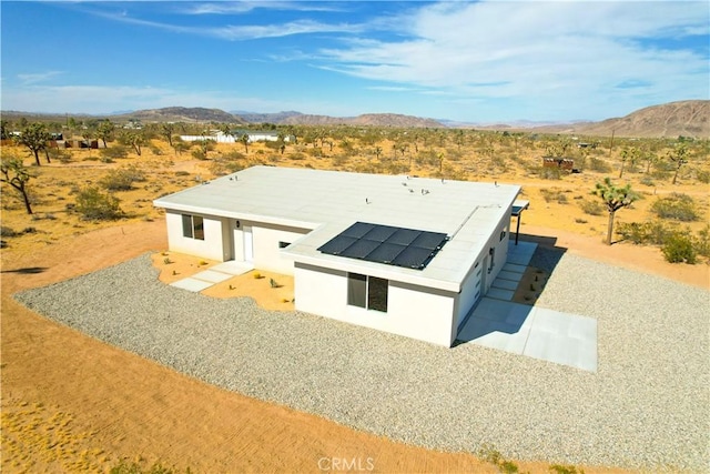 exterior space featuring a mountain view and solar panels