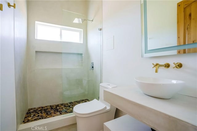 bathroom with sink, toilet, and a tile shower