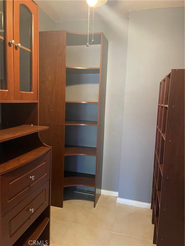 walk in closet with light tile patterned floors