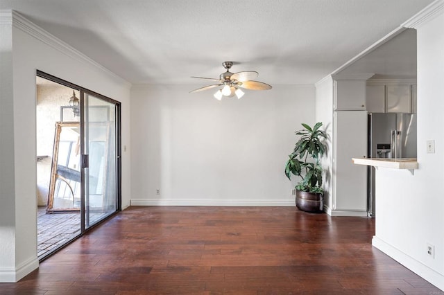 interior space with baseboards, crown molding, ceiling fan, and wood finished floors