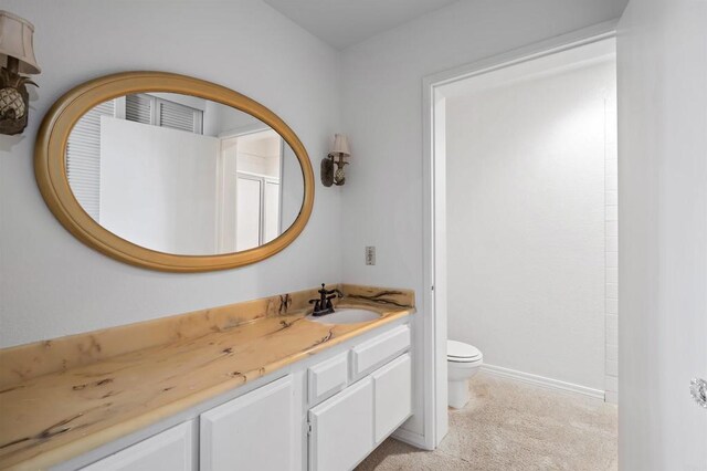 full bath featuring toilet, vanity, and baseboards