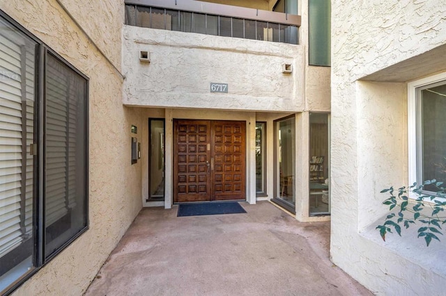 entrance to property featuring stucco siding