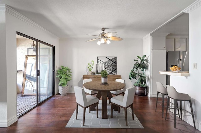 dining room with dark wood-style floors, crown molding, and a ceiling fan