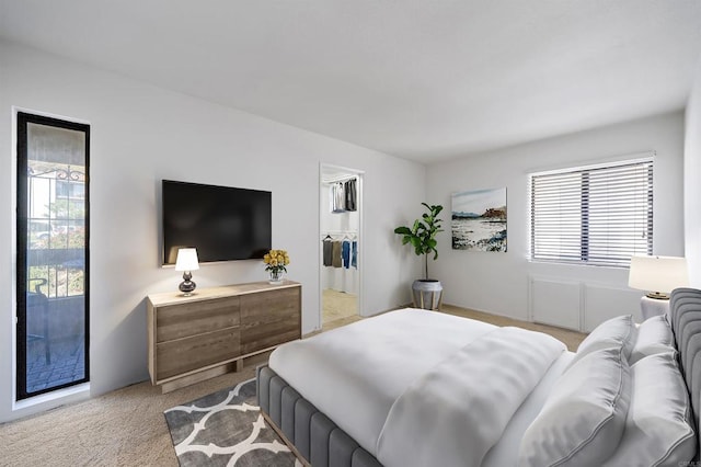 bedroom featuring light carpet and a spacious closet