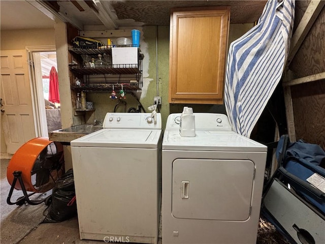 clothes washing area featuring cabinets and washing machine and clothes dryer