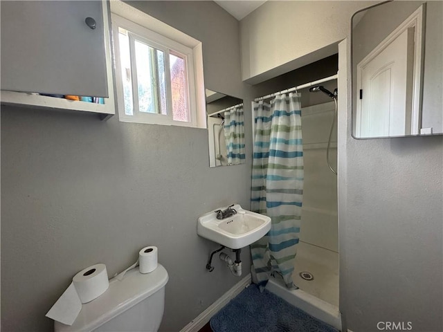 bathroom with toilet and a shower with shower curtain