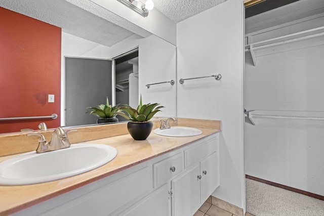 bathroom featuring vanity, tile patterned floors, and a textured ceiling