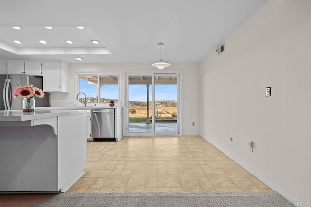 kitchen with white cabinetry, appliances with stainless steel finishes, and decorative light fixtures