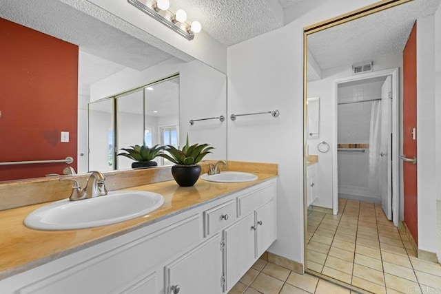 bathroom featuring tile patterned flooring, vanity, a shower with curtain, and a textured ceiling