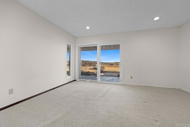 carpeted empty room featuring a textured ceiling