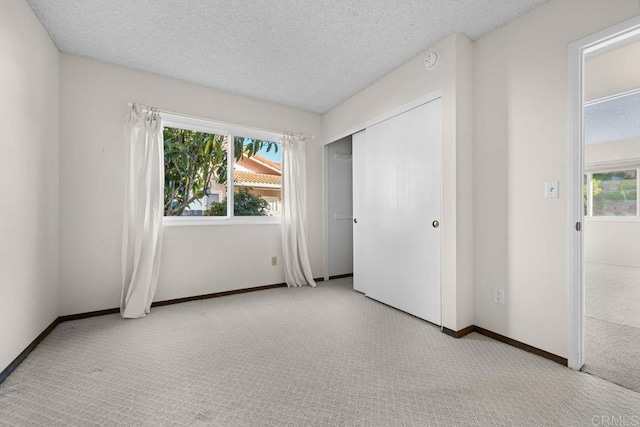 unfurnished bedroom with light carpet and a textured ceiling