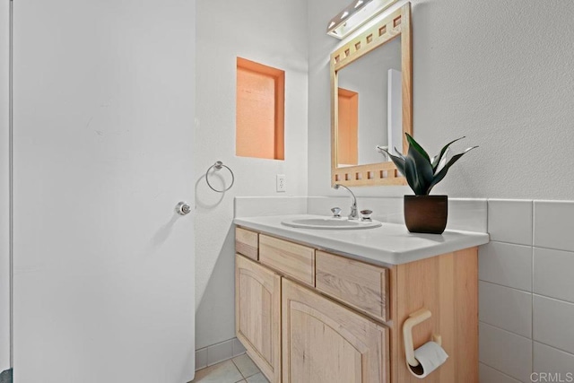 bathroom with tile patterned floors, vanity, and tile walls