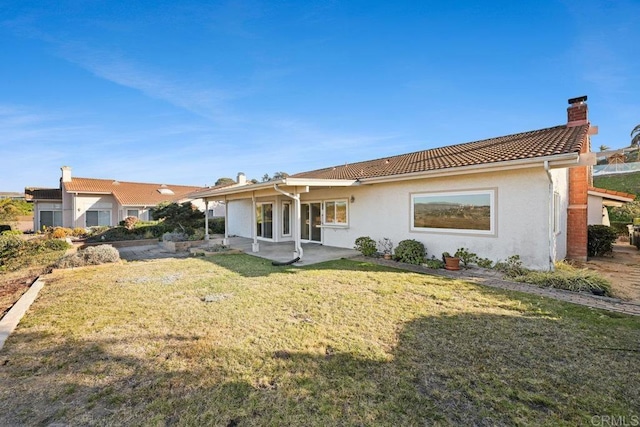 rear view of house with a patio area and a lawn