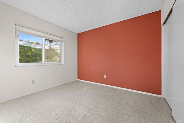 empty room featuring carpet and a textured ceiling