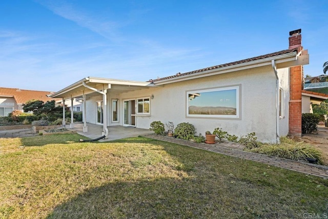 rear view of house featuring a patio and a yard