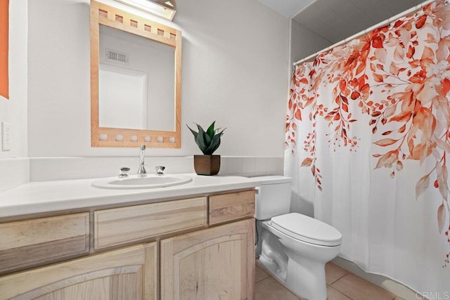 bathroom featuring vanity, tile patterned floors, and toilet