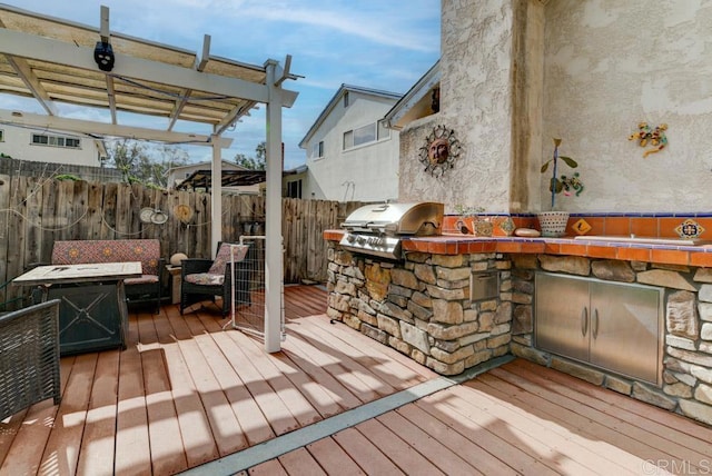 deck featuring exterior kitchen, area for grilling, an outdoor living space, and a pergola