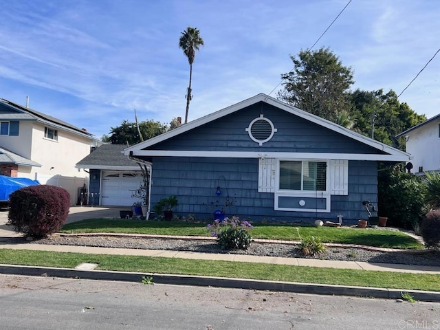 bungalow-style home featuring a garage and a front lawn