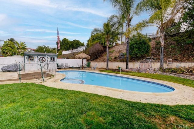 view of pool featuring an outbuilding and a lawn