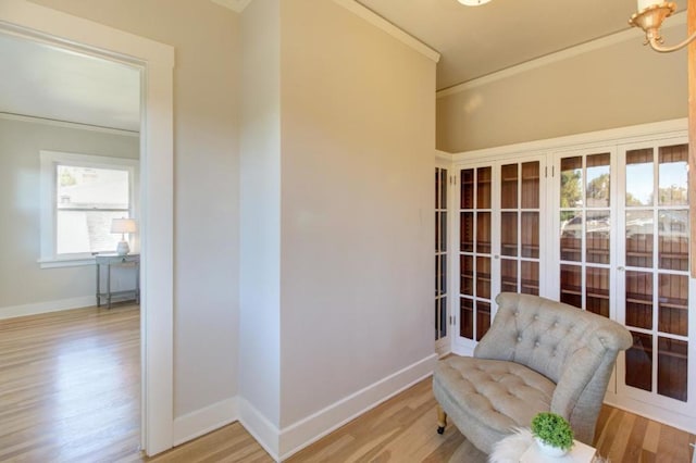 sitting room with light hardwood / wood-style flooring and crown molding