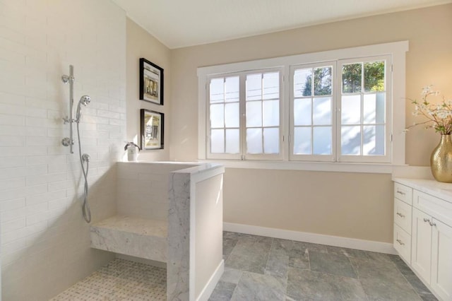 bathroom with vanity and a tile shower