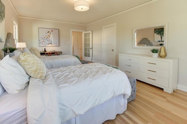 bedroom with crown molding and light hardwood / wood-style floors