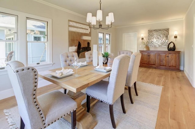 dining space featuring crown molding, a chandelier, and light wood-type flooring