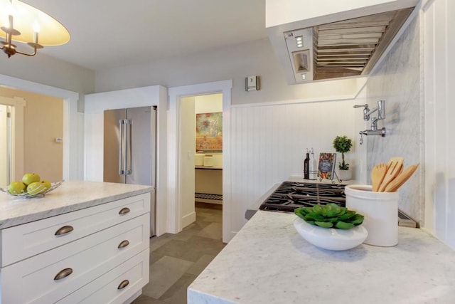 kitchen featuring white cabinetry, high quality fridge, and hanging light fixtures