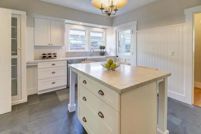 kitchen with white cabinets, dishwasher, a center island, and hanging light fixtures