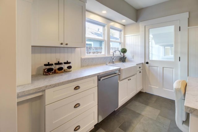 kitchen with light stone countertops, tasteful backsplash, dishwasher, sink, and white cabinets