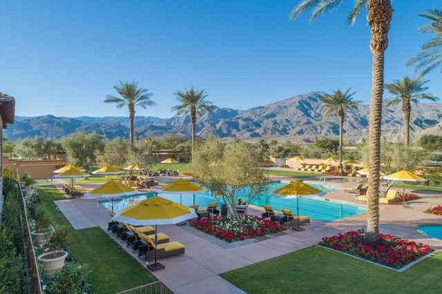 exterior space featuring a mountain view, a patio area, and a pool