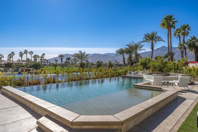 view of swimming pool with a mountain view and a patio area