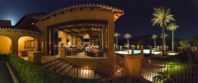 patio at twilight featuring a community pool