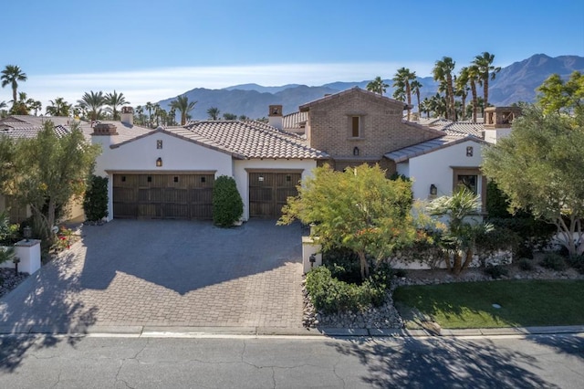 mediterranean / spanish-style home with a mountain view and a garage