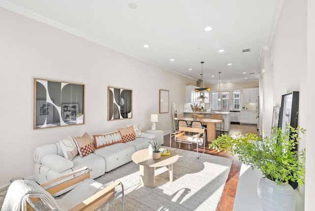 living room with crown molding and light hardwood / wood-style flooring