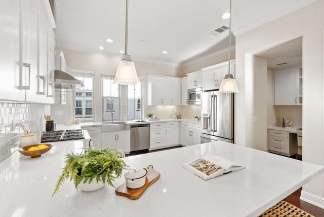 kitchen with crown molding, stainless steel appliances, decorative backsplash, white cabinets, and decorative light fixtures