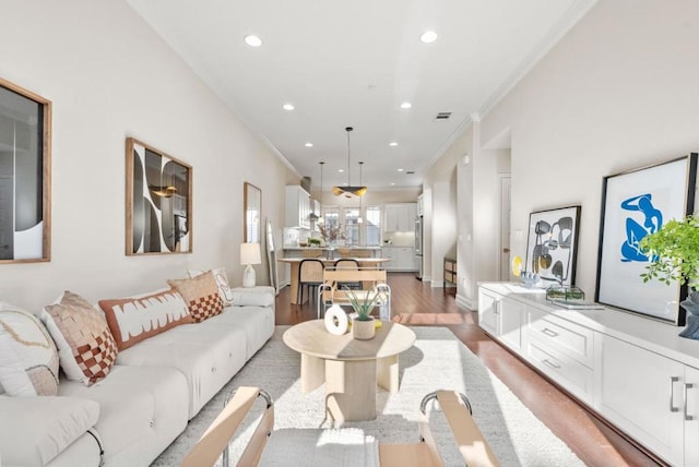 living room with hardwood / wood-style flooring and ornamental molding