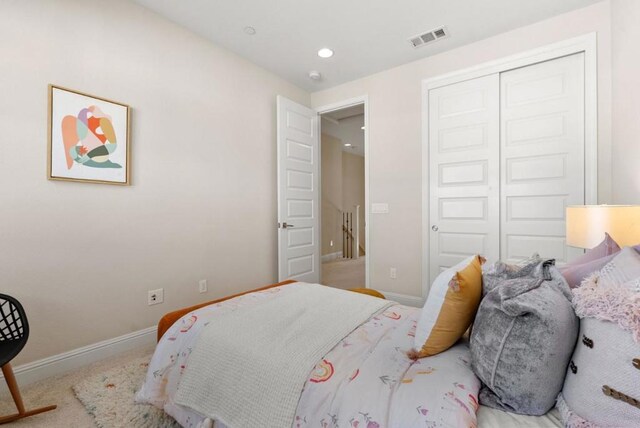 bedroom with light carpet and a closet