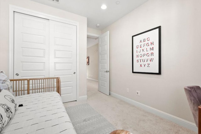 bedroom featuring light carpet and a closet